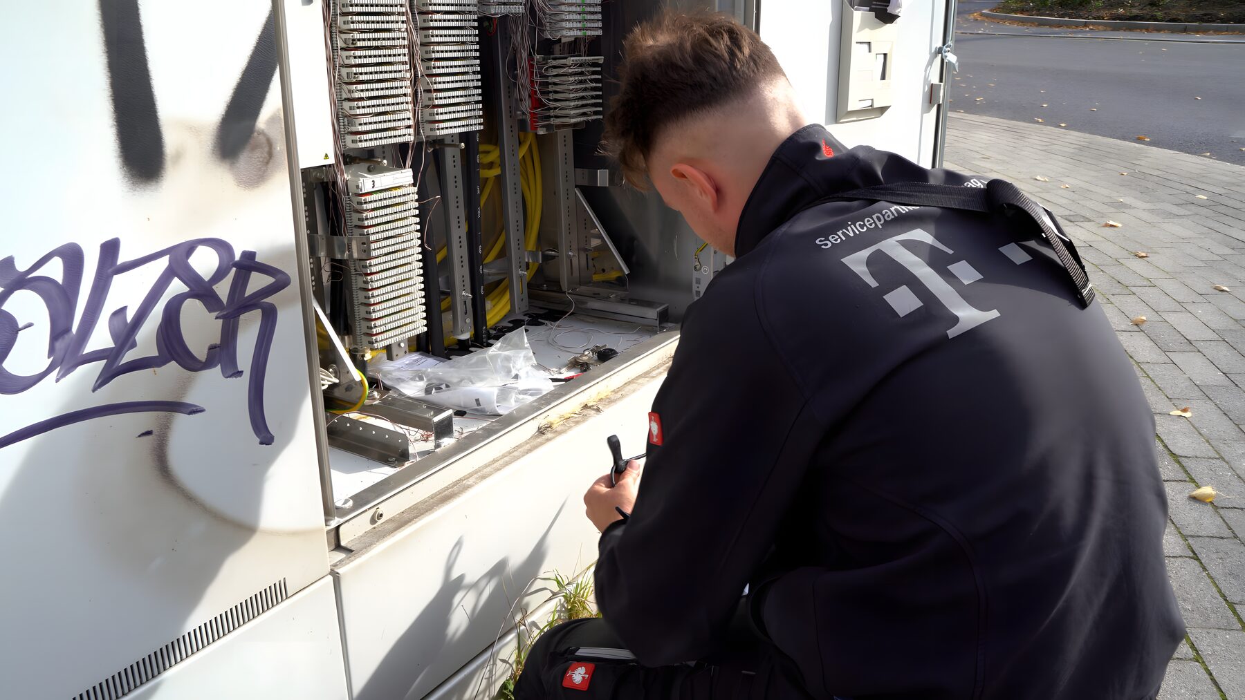 Techniker arbeitet am geöffneten Kabelverzweiger